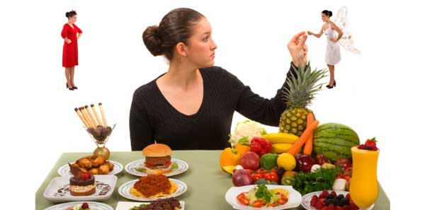A woman sits at a table full of various foods, contemplating a choice between unhealthy and healthy options, represented by small figures in red and white dresses. The scene illustrates a decision-making process regarding nutrition and lifestyle.