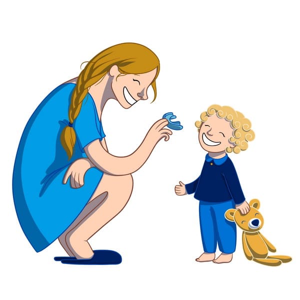 A smiling woman in a blue dress interacts joyfully with a young child holding a teddy bear. The child, with curly blonde hair, appears delighted while the woman playfully holds up a butterfly toy. The scene radiates warmth and happiness.