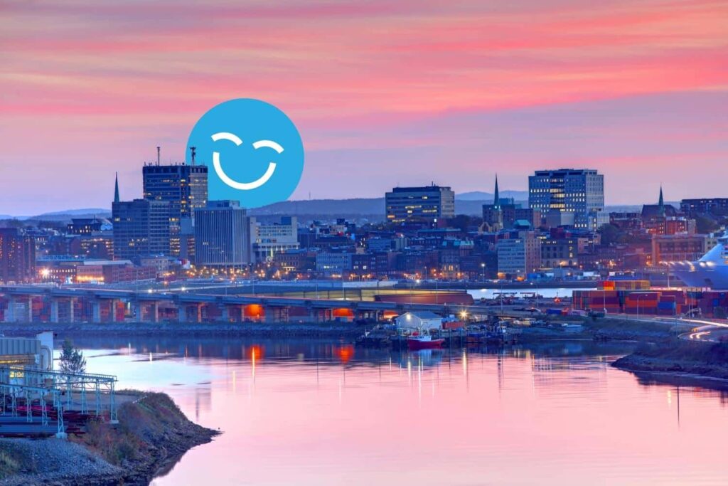A serene city skyline at sunset, reflecting in the water below. A large blue smiley face overlays the scene, adding a cheerful element to the tranquil atmosphere.