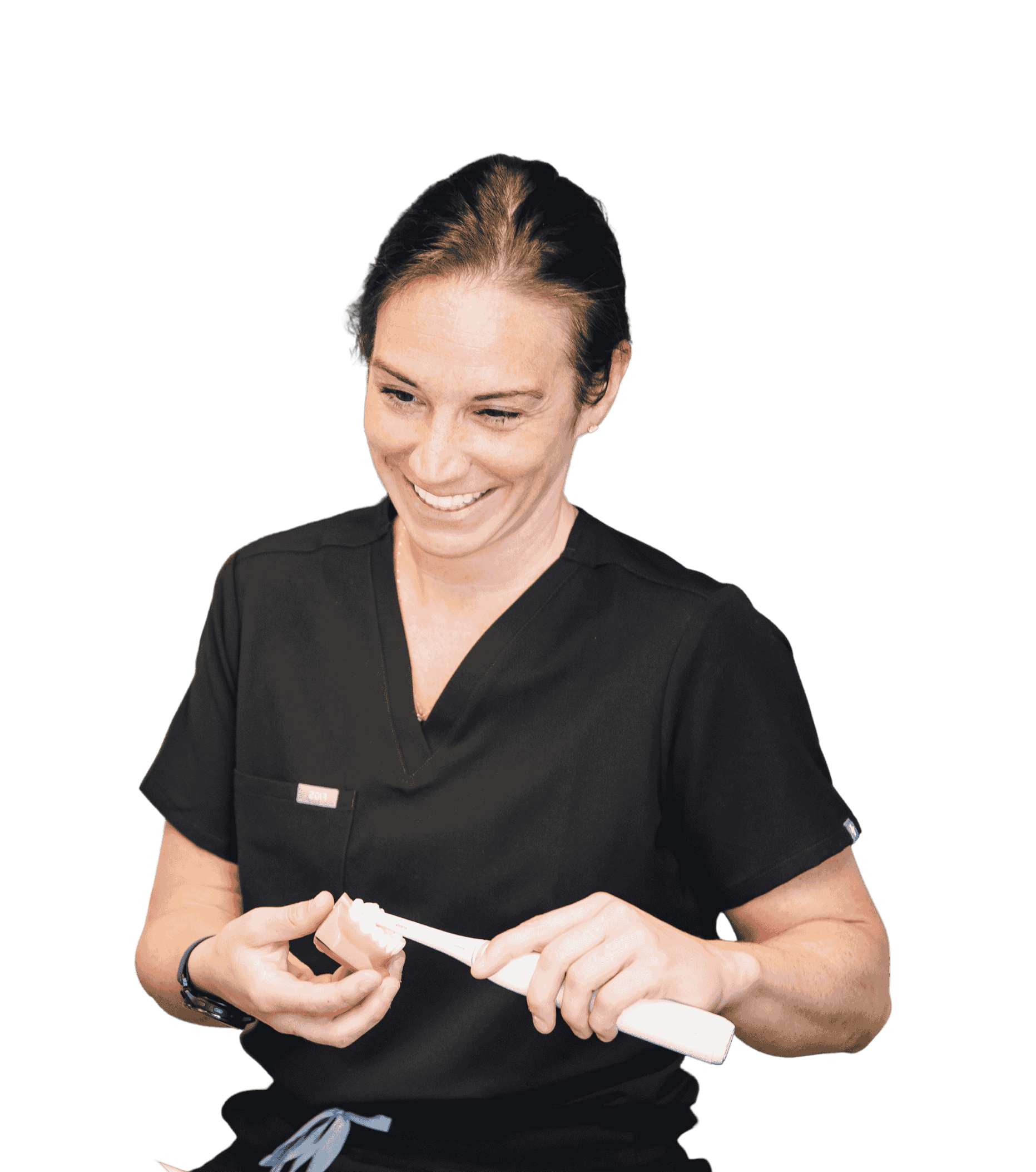A smiling dental professional in black scrubs holds a dental tool while preparing for a procedure. Her friendly demeanor conveys a warm and approachable atmosphere in a clinical setting.