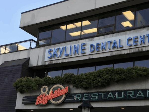 A multi-story building facade featuring "Skyline Dental Centre" and "800 Restaurant" signs, with windows and greenery.